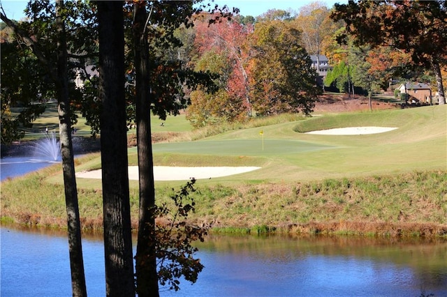 view of home's community with a lawn and a water view