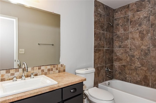 full bathroom with vanity, tasteful backsplash, toilet, and tiled shower / bath