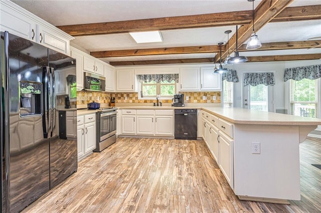 130 Brooklet Way, Brooks, GA 30205 - kitchen featuring black appliances, a peninsula, light wood-style flooring, backsplash, and beamed ceiling