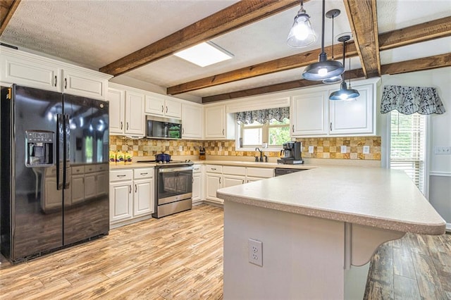 130 Brooklet Way, Brooks, GA 30205 - kitchen featuring appliances with stainless steel finishes, a peninsula, light wood-style flooring, backsplash, and beamed ceiling