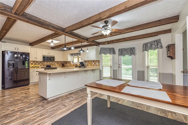 130 Brooklet Way, Brooks, GA 30205 - kitchen with black fridge, stainless steel microwave, dark wood-style floors, a peninsula, and backsplash