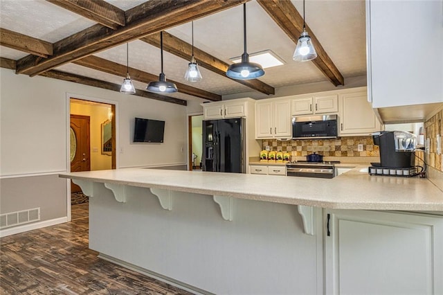 130 Brooklet Way, Brooks, GA 30205 - kitchen with black refrigerator with ice dispenser, stainless steel microwave, backsplash, dark wood finished floors, and a peninsula