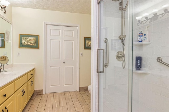 130 Brooklet Way, Brooks, GA 30205 - bathroom featuring vanity, a shower stall, a textured ceiling, and wood finish floors