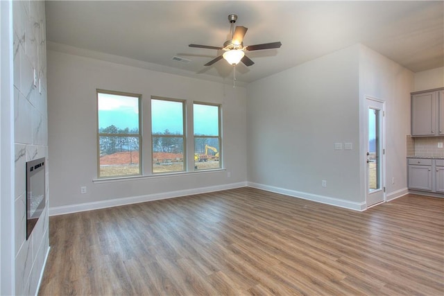 96 Sherwood Dr, Commerce, GA 30529 - unfurnished living room with light wood-type flooring, baseboards, visible vents, a ceiling fan, and heating unit