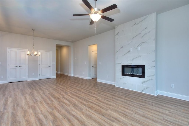 96 Sherwood Dr, Commerce, GA 30529 - unfurnished living room with a high end fireplace, baseboards, ceiling fan with notable chandelier, and light wood-type flooring