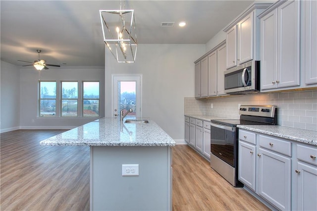 96 Sherwood Dr, Commerce, GA 30529 - kitchen featuring stainless steel appliances, visible vents, light wood-style floors, backsplash, and gray cabinets