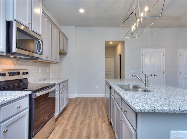 96 Sherwood Dr, Commerce, GA 30529 - kitchen with a notable chandelier, a sink, gray cabinets, light wood finished floors, and appliances with stainless steel finishes