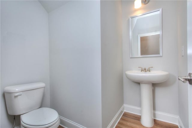 96 Sherwood Dr, Commerce, GA 30529 - half bathroom featuring a sink, toilet, wood finished floors, and baseboards