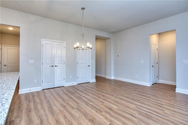 96 Sherwood Dr, Commerce, GA 30529 - unfurnished dining area with light wood finished floors, baseboards, and a notable chandelier