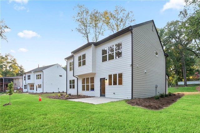 rear view of property featuring a patio area and a lawn