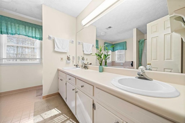 full bath with a textured ceiling, tile patterned flooring, a sink, and visible vents