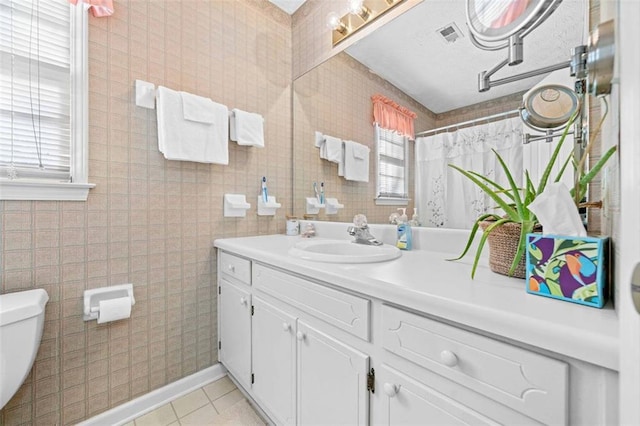 full bathroom with vanity, a wealth of natural light, tile patterned flooring, and toilet