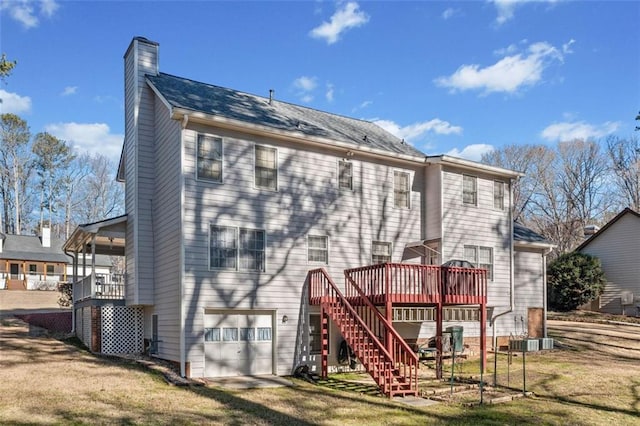 rear view of property with a garage, stairs, driveway, a lawn, and a chimney