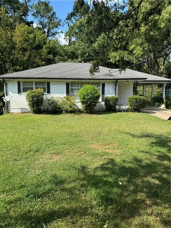 single story home with a front lawn and a carport