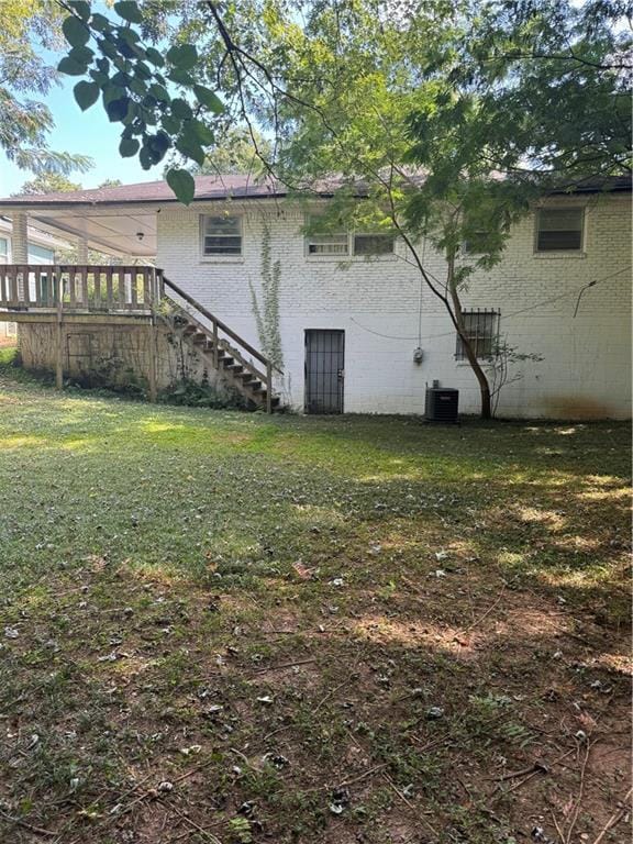 back of house featuring central AC and a yard