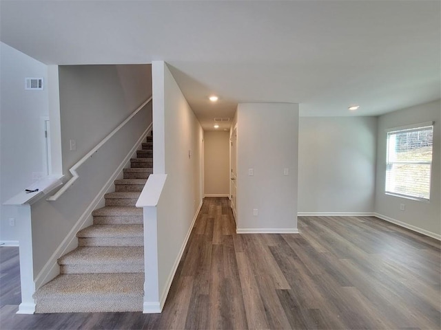 stairs featuring wood finished floors, baseboards, and recessed lighting