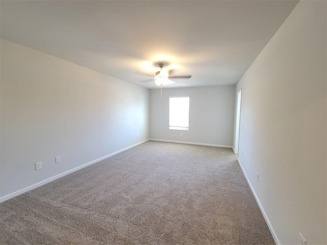 spare room featuring a ceiling fan, carpet flooring, and baseboards