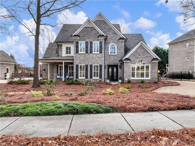 view of front of home featuring fence and brick siding