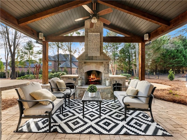 view of patio / terrace featuring a gazebo, an outdoor living space with a fireplace, ceiling fan, and fence