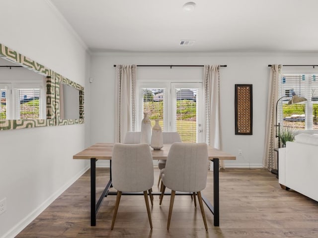 dining room featuring ornamental molding and wood-type flooring