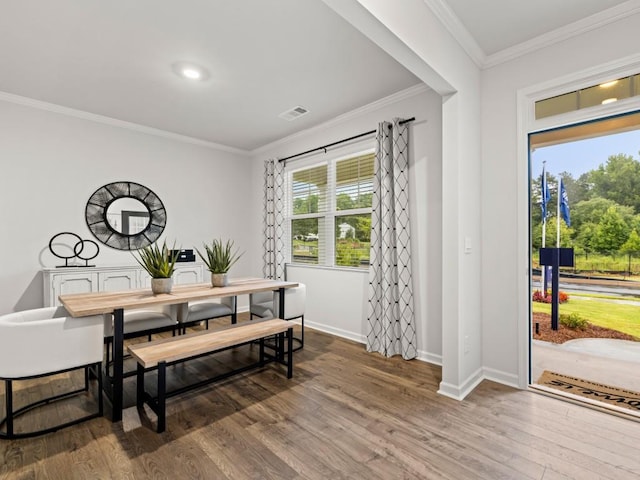 dining space featuring hardwood / wood-style floors and crown molding