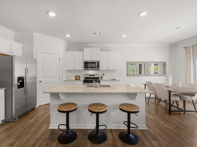 kitchen featuring stainless steel appliances, an island with sink, and white cabinets