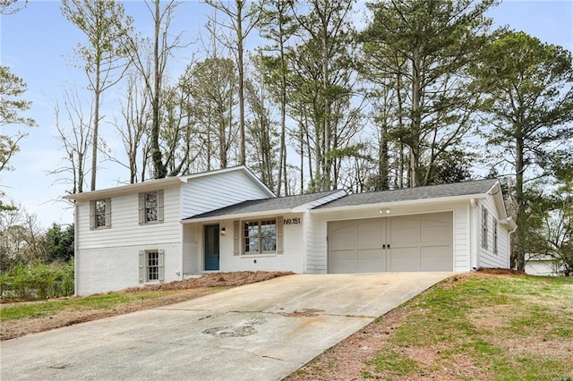 split level home with a garage, concrete driveway, and brick siding