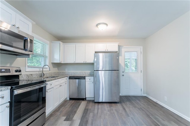 5795 Deerfield Trl, Atlanta, GA 30349 - kitchen with appliances with stainless steel finishes, a sink, wood finished floors, and white cabinetry