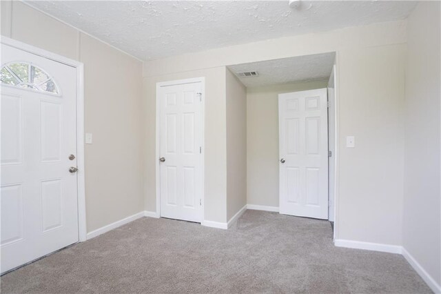 5795 Deerfield Trl, Atlanta, GA 30349 - entryway with carpet flooring, a textured ceiling, and baseboards