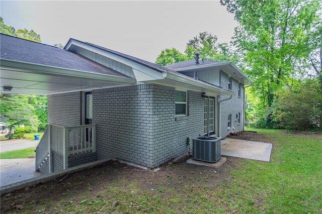 5795 Deerfield Trl, Atlanta, GA 30349 - back of property featuring central AC, a patio area, a yard, and brick siding