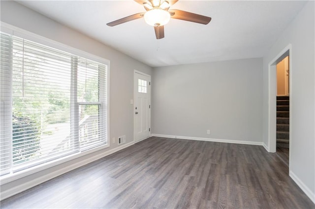5795 Deerfield Trl, Atlanta, GA 30349 - empty room with dark wood finished floors, baseboards, stairs, and ceiling fan