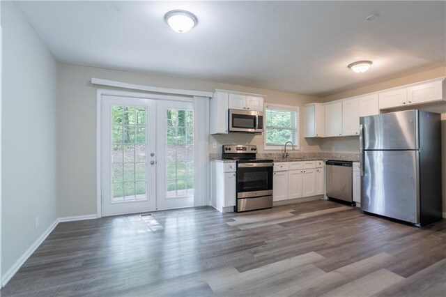5795 Deerfield Trl, Atlanta, GA 30349 - kitchen with stainless steel appliances, white cabinetry, and dark wood finished floors