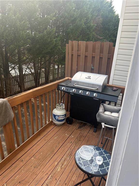 wooden terrace with grilling area and fence