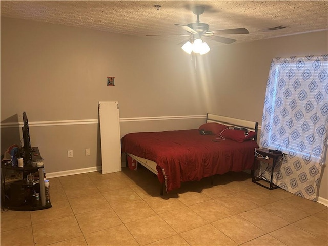 bedroom featuring visible vents, a textured ceiling, and light tile patterned floors