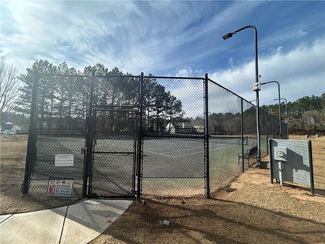 view of sport court with a gate and fence