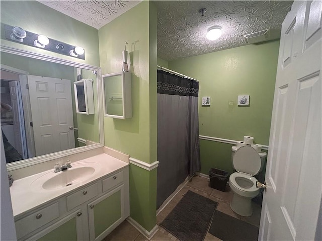 bathroom with toilet, tile patterned floors, a textured ceiling, and vanity