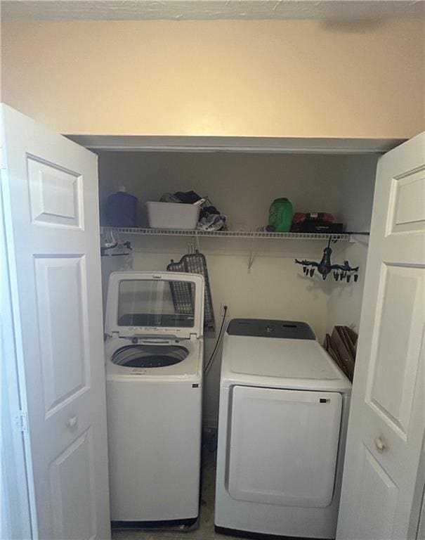 washroom featuring laundry area and washing machine and dryer