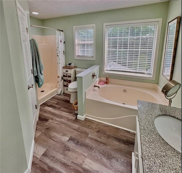 5624 Ryan Way, Flowery Branch, GA 30542 - bathroom with wood finished floors, a garden tub, a stall shower, a textured ceiling, and vanity