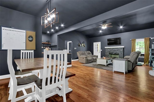 dining area with a fireplace, a ceiling fan, baseboards, wood finished floors, and lofted ceiling