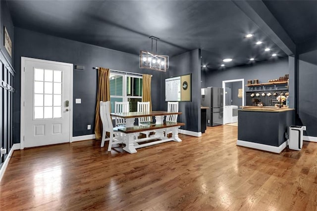 interior space featuring baseboards, wood finished floors, and a chandelier