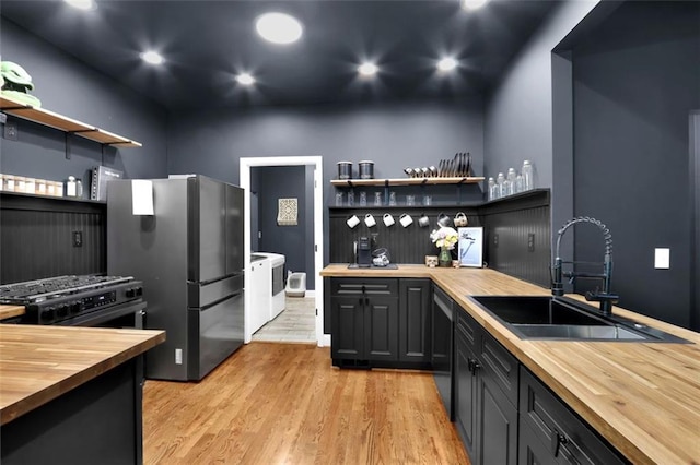 kitchen with separate washer and dryer, open shelves, butcher block countertops, and a sink