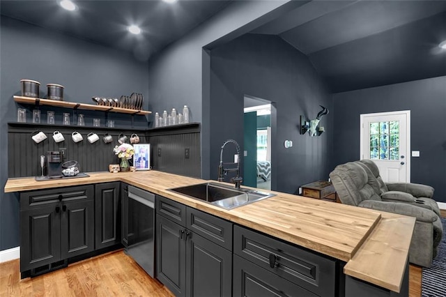 interior space with a sink, light wood finished floors, lofted ceiling, and dishwasher