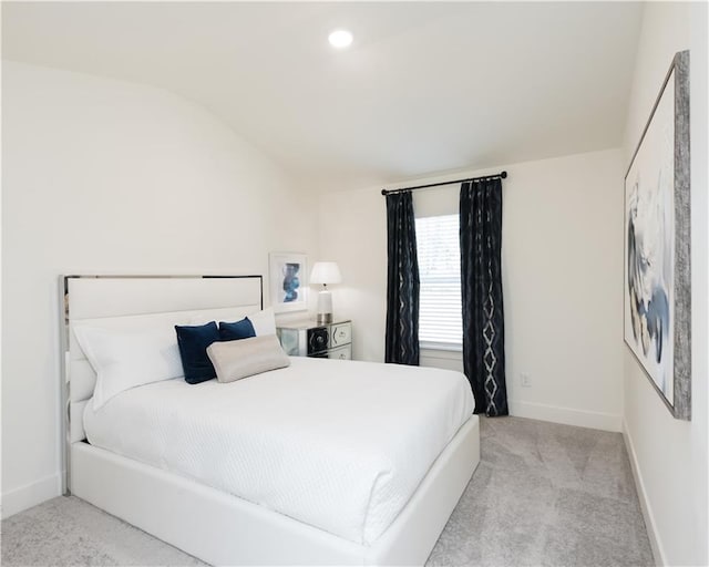 bedroom with vaulted ceiling and light colored carpet