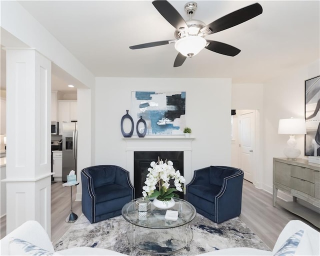 living room with ceiling fan and light wood-type flooring