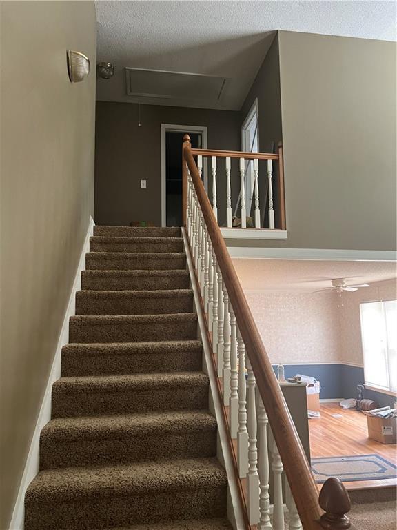50 Ranger Rd SE, Cartersville, GA 30121 - stairs with attic access, ceiling fan, and a textured ceiling