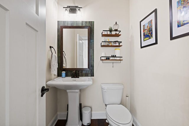 half bath with toilet and baseboards