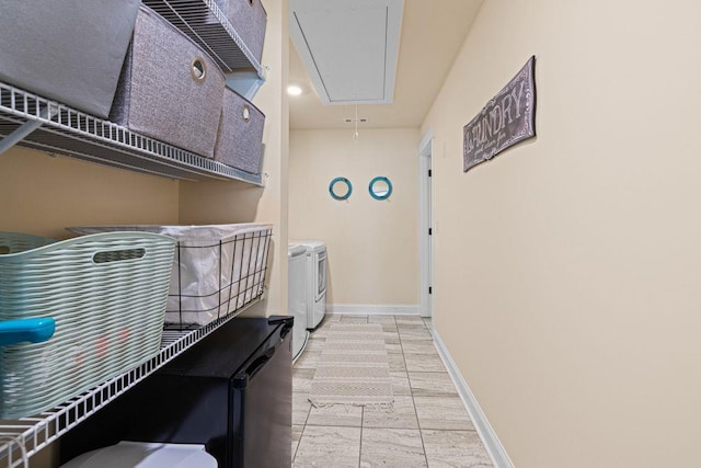 laundry area featuring baseboards, separate washer and dryer, attic access, and laundry area