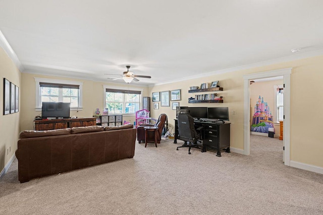 living area featuring light colored carpet, a ceiling fan, baseboards, and ornamental molding