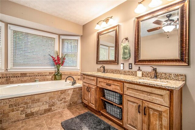 full bath with a bath, double vanity, ceiling fan, and a sink