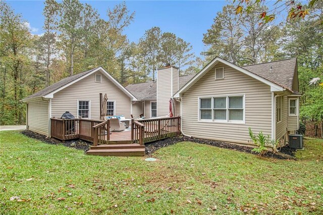 back of house featuring central AC, a wooden deck, and a lawn